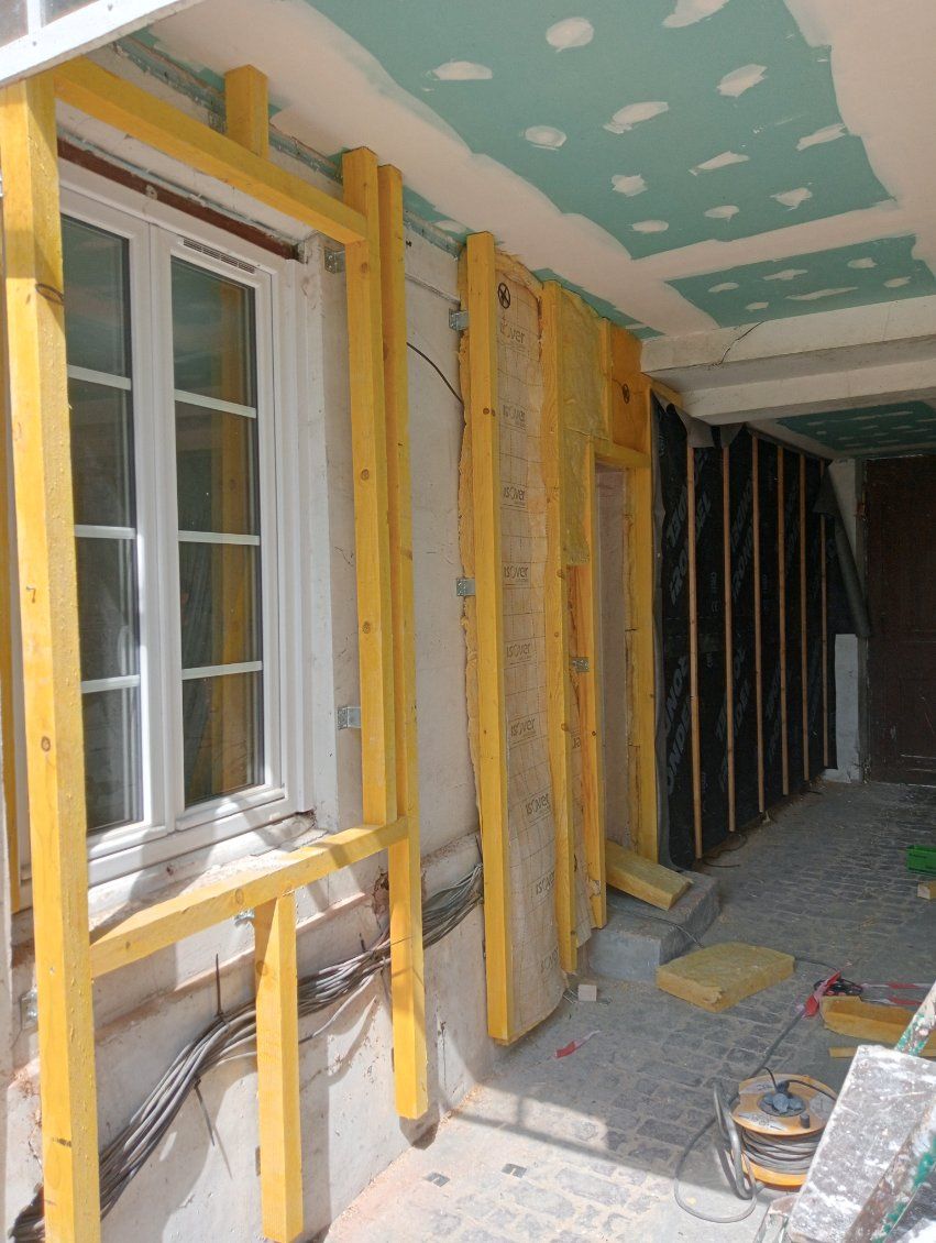 Encadrement en bois posé contre une façade sous un porche