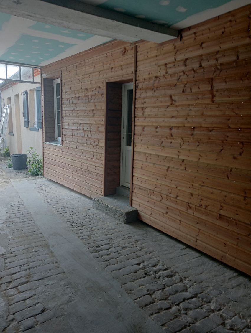 Bardage en bois contre une façade sous un porche
