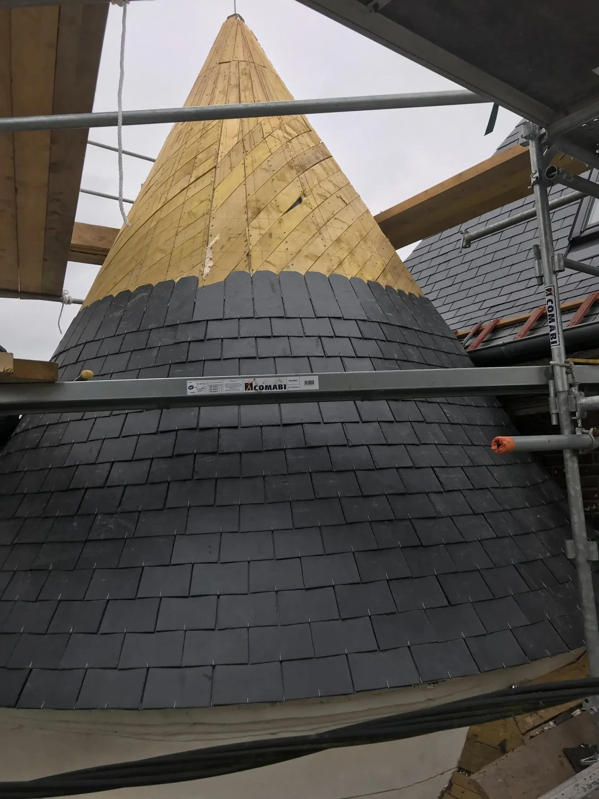 Ardoise en cours de pose sur un toit en forme de cône