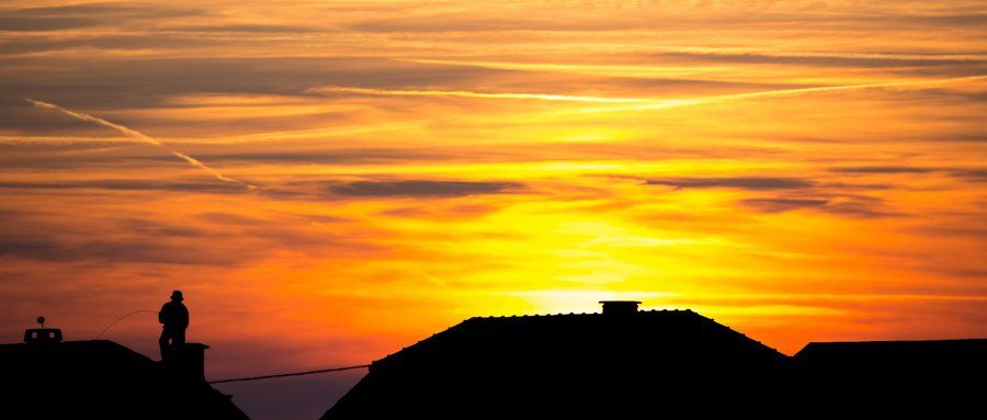 Ramoneur sur un toit avec couché de soleil