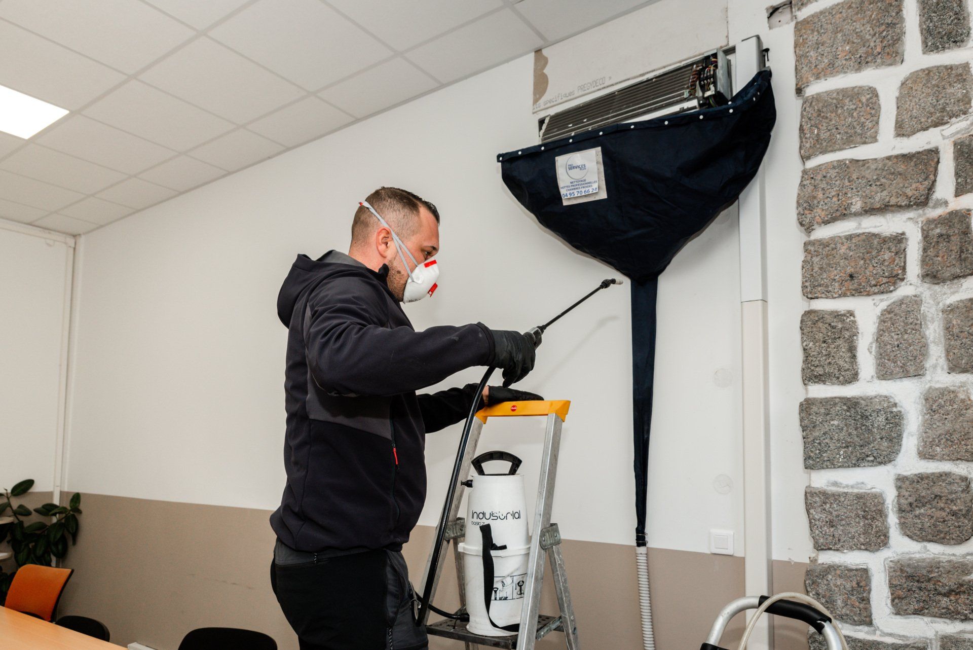 Membre de Pro Services Plus nettoyant une climatisation en intérieur
