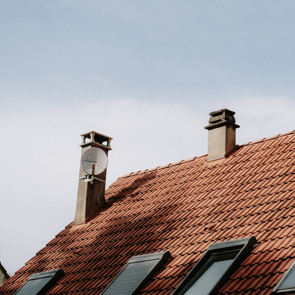 Deux cheminées sur un toit avec un ciel obscur en fond