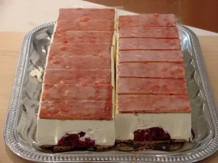 Zwei rechteckige, geschichtete Dessertriegel mit rosa Oberseite in einer Alufolienschale