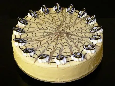 Runder Sahnekuchen mit Schokoladenswirl-Glasur und Zuckerstückchen als Garnitur