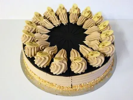 Schokoladen- und Vanillekuchen mit Zuckerguss, Goldrand und aufgespritzten Sahnetupfen