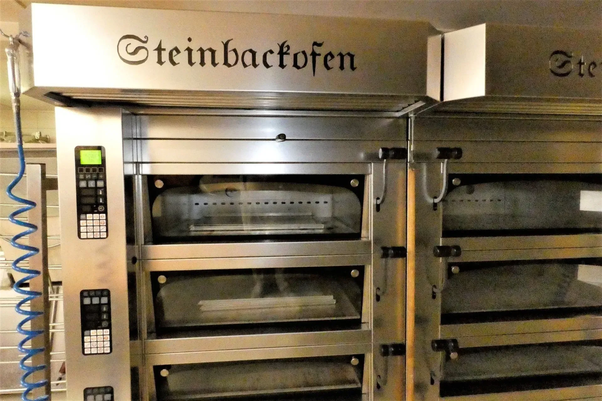 Industrielle Edelstahlöfen mit digitaler Steuerung in einer gewerblichen Bäckereiküche