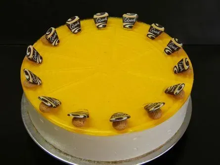 Gelber, glasierter Kuchen mit kleinen Bonbonstückchen am oberen Rand.
