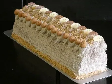 Länglicher, rechteckiger, mit Zuckerguss überzogener Kuchen mit dekorativen Baiserspitzen auf dunklem Hintergrund