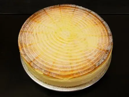 Runder gelber Biskuitkuchen mit konzentrischen Ringen auf einem durchsichtigen Teller