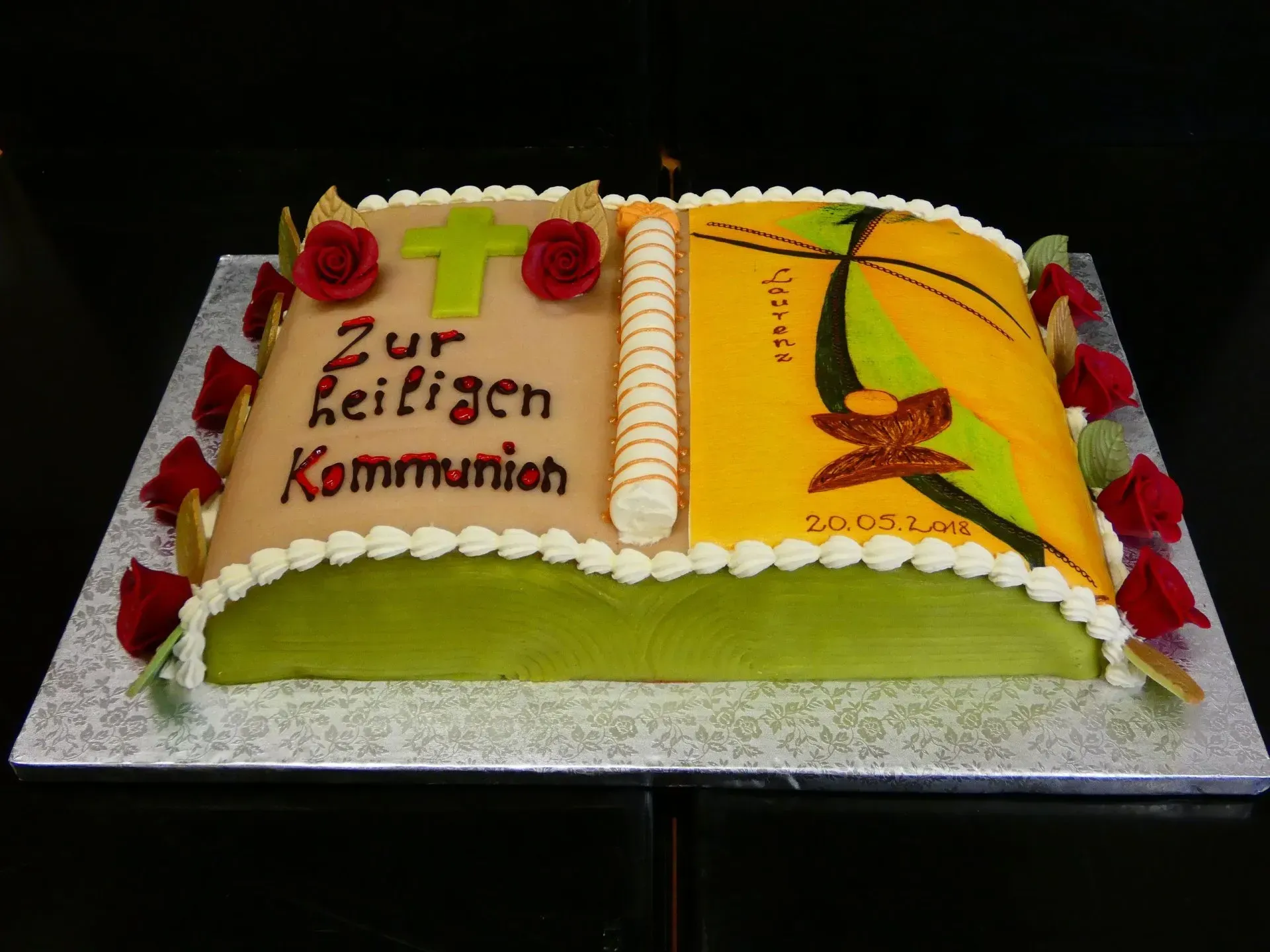 Aufgeschlagene, buchförmige Torte mit roten Rosen und deutschem Text auf einem silbernen Tablett