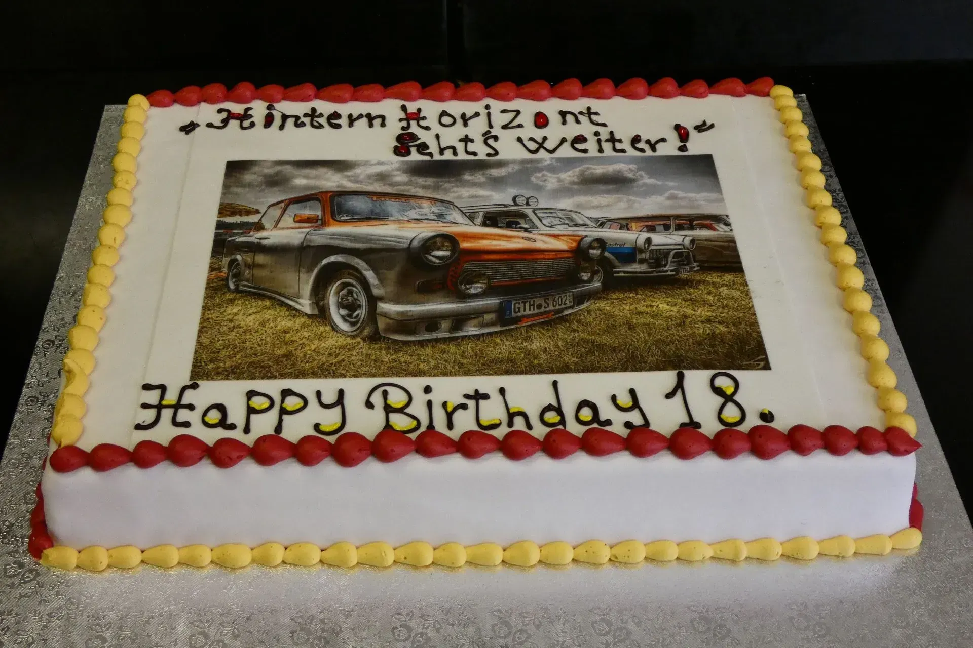 Geburtstagstorte mit Oldtimer-Motiv und der Aufschrift „Happy Birthday 18“.