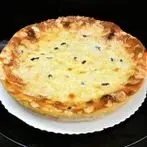 Käsekuchen in goldbrauner Kruste auf einem weißen Teller