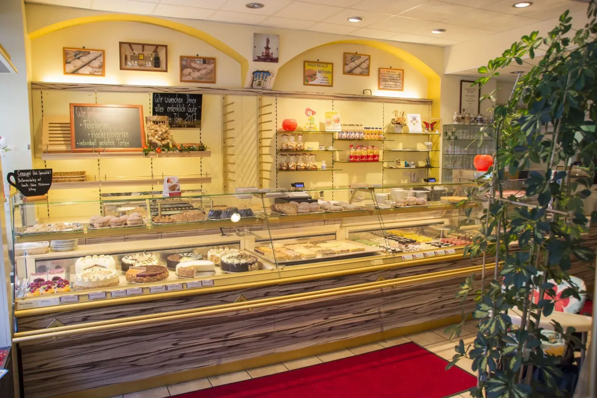 Auslage einer Bäckerei mit verschiedenen Gebäcksorten in einem warm beleuchteten Ladenlokal