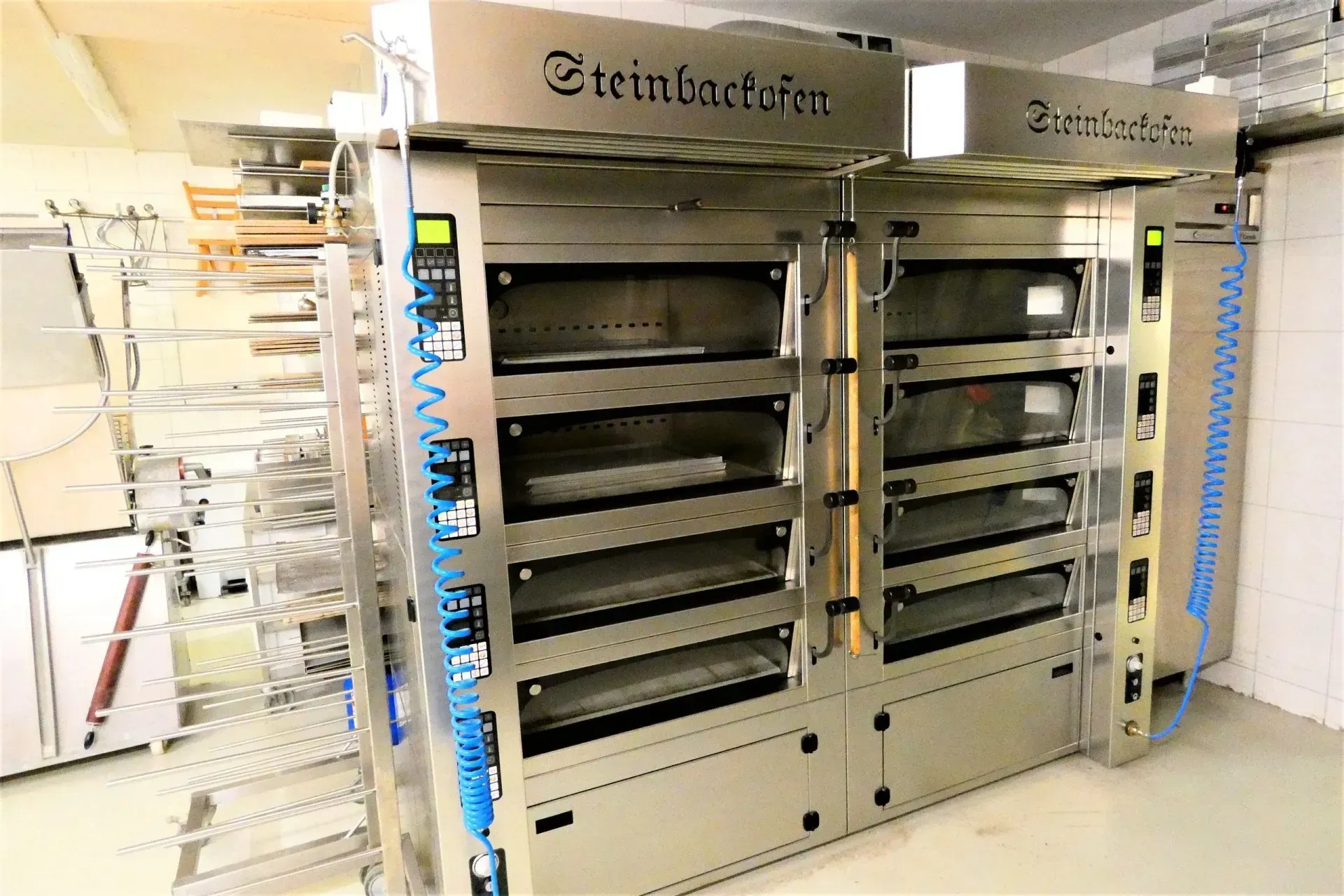 Große Industriebacköfen mit Metallgestellen in einer hellen Gewerbeküche