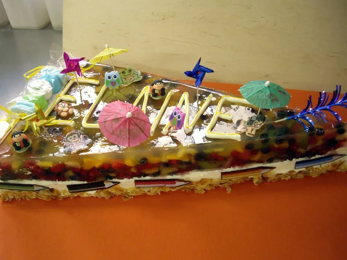 Ein farbenfroh dekorierter Kuchen mit Kerzen, Sternen und Blumen auf einem Tisch