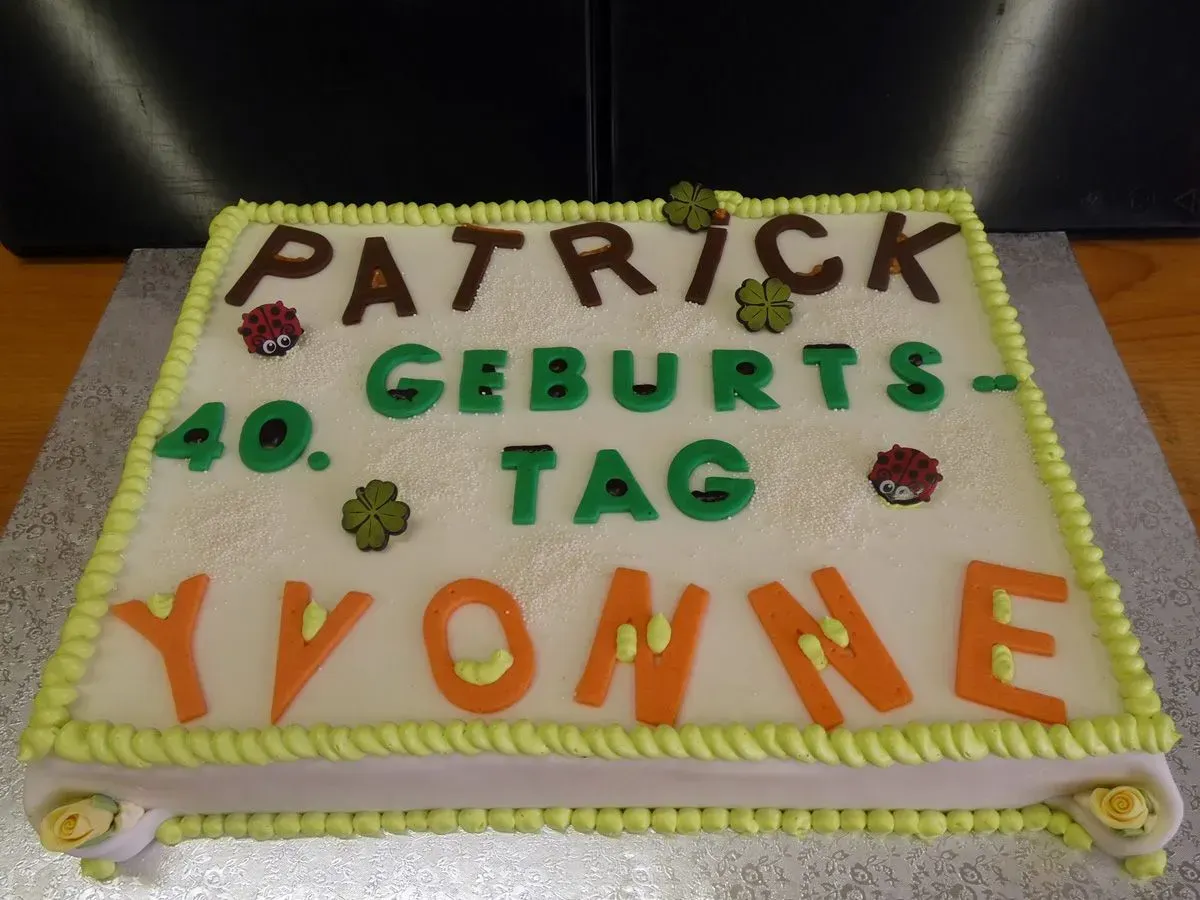 Verzierte Geburtstagstorte mit der Aufschrift „Patrick 40. Geburts-Tag Yvonne“ in bunten Buchstaben