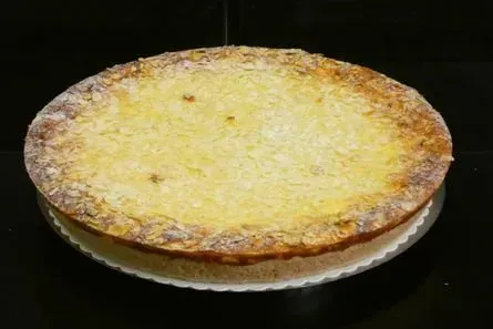 Käsepizza auf einem Teller vor dunklem Hintergrund