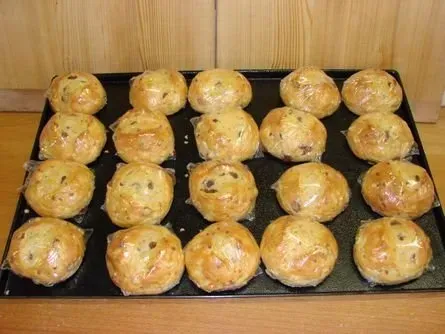 Ein Tablett mit frisch gebackenen, goldgelben Muffins in Papierförmchen auf einem Backblech