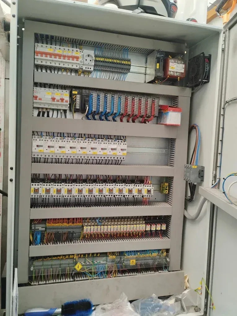 Panel eléctrico abierto repleto de circuitos, cables y componentes.