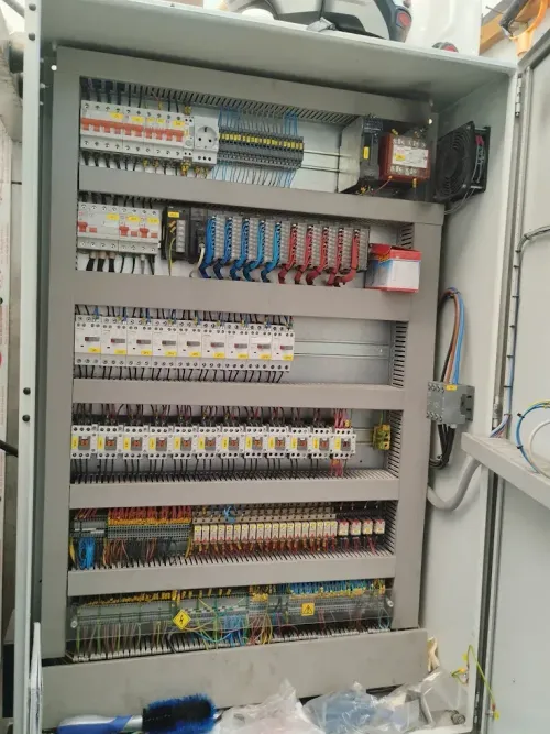 Panel eléctrico abierto repleto de circuitos, cables y componentes.