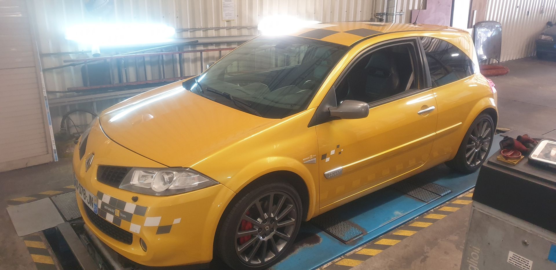 Une voiture jaune avec un damier sur le toit.