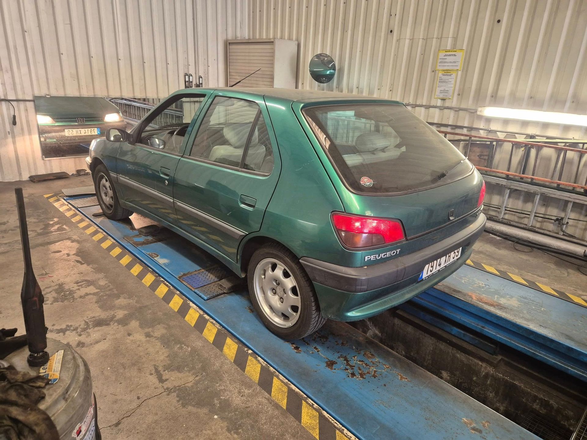 Une voiture verte de la marque Peugeot.