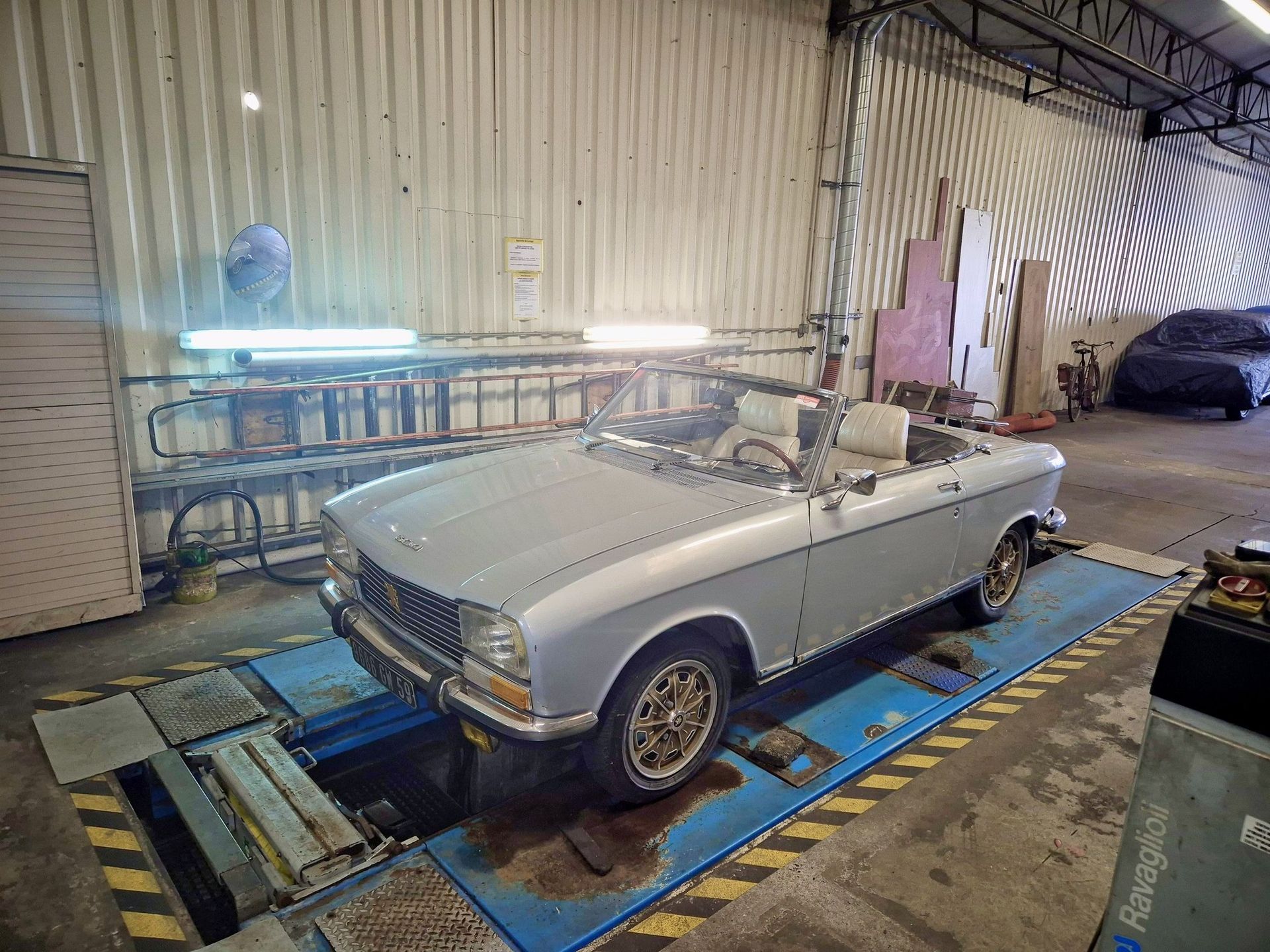 Une voiture de collection grise et décapotable.