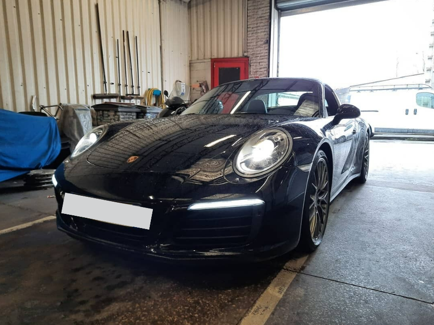 Une voiture noire de la marque Porsche.