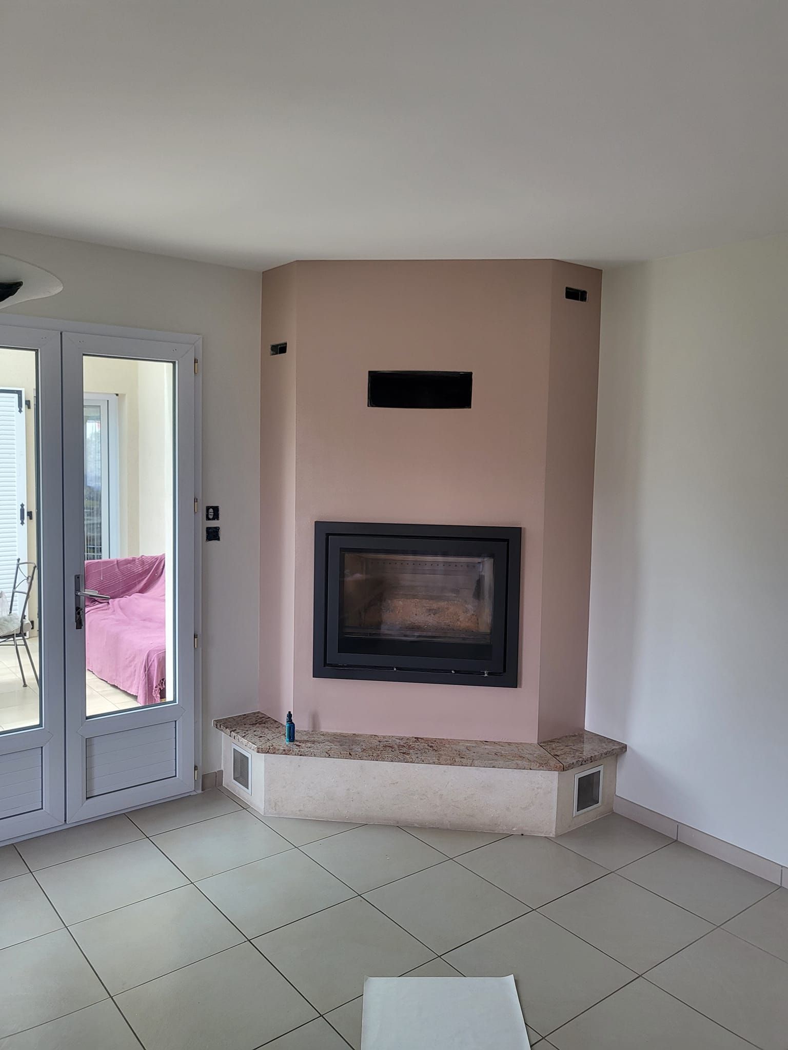 Photo d'un mur de cheminée peint en rose pâle