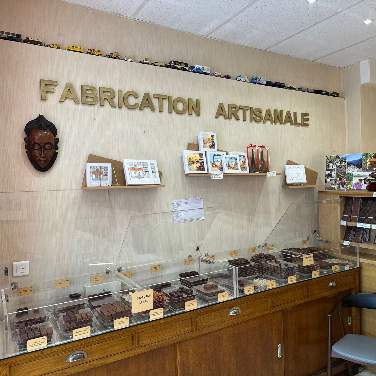 Vitrine de chocolats artisanaux dans une boutique portant l'enseigne « fabrication artisanale ».