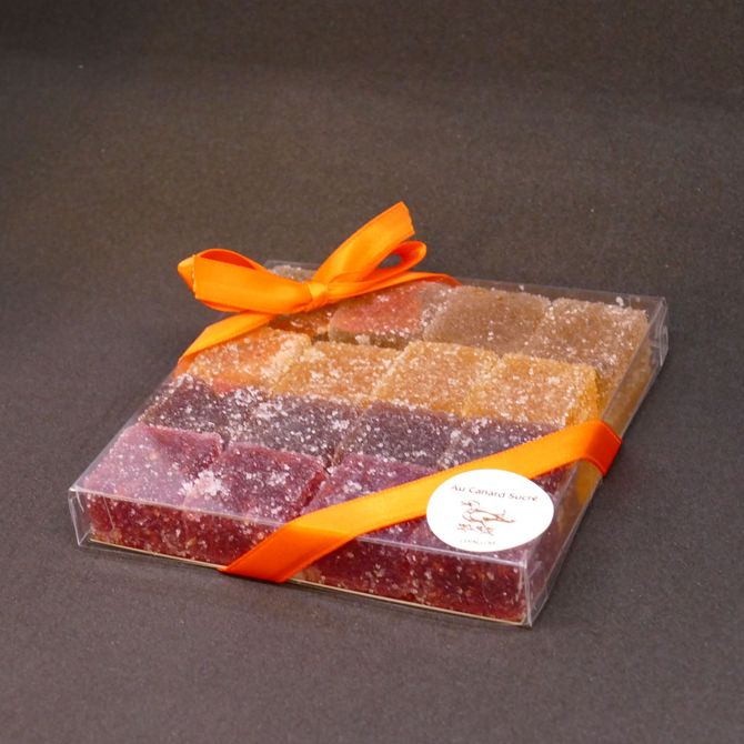 Boîte cadeau emballée dans du plastique transparent avec un ruban orange sur fond sombre