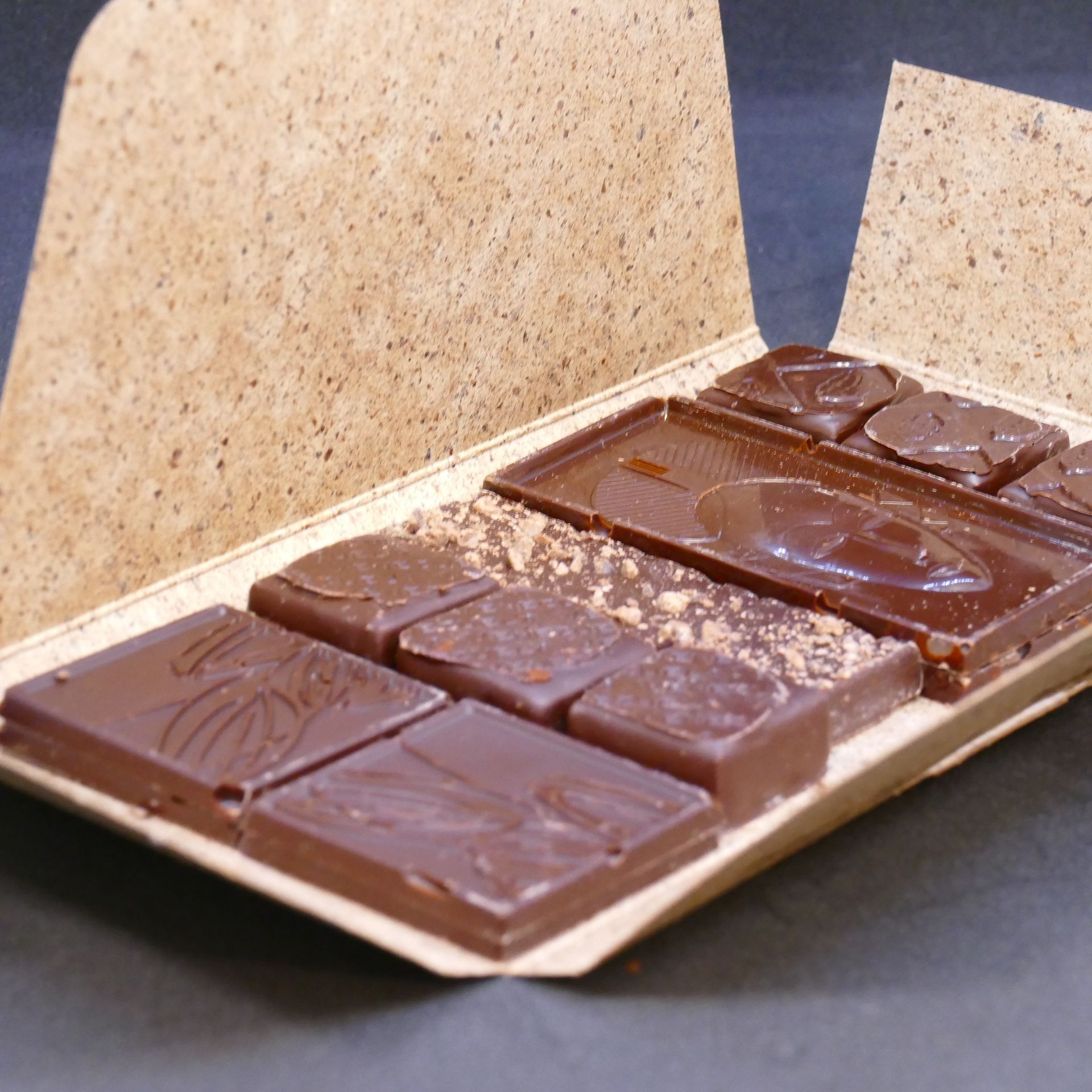 Chocolats au lait dans un plateau en carton avec des morceaux en relief