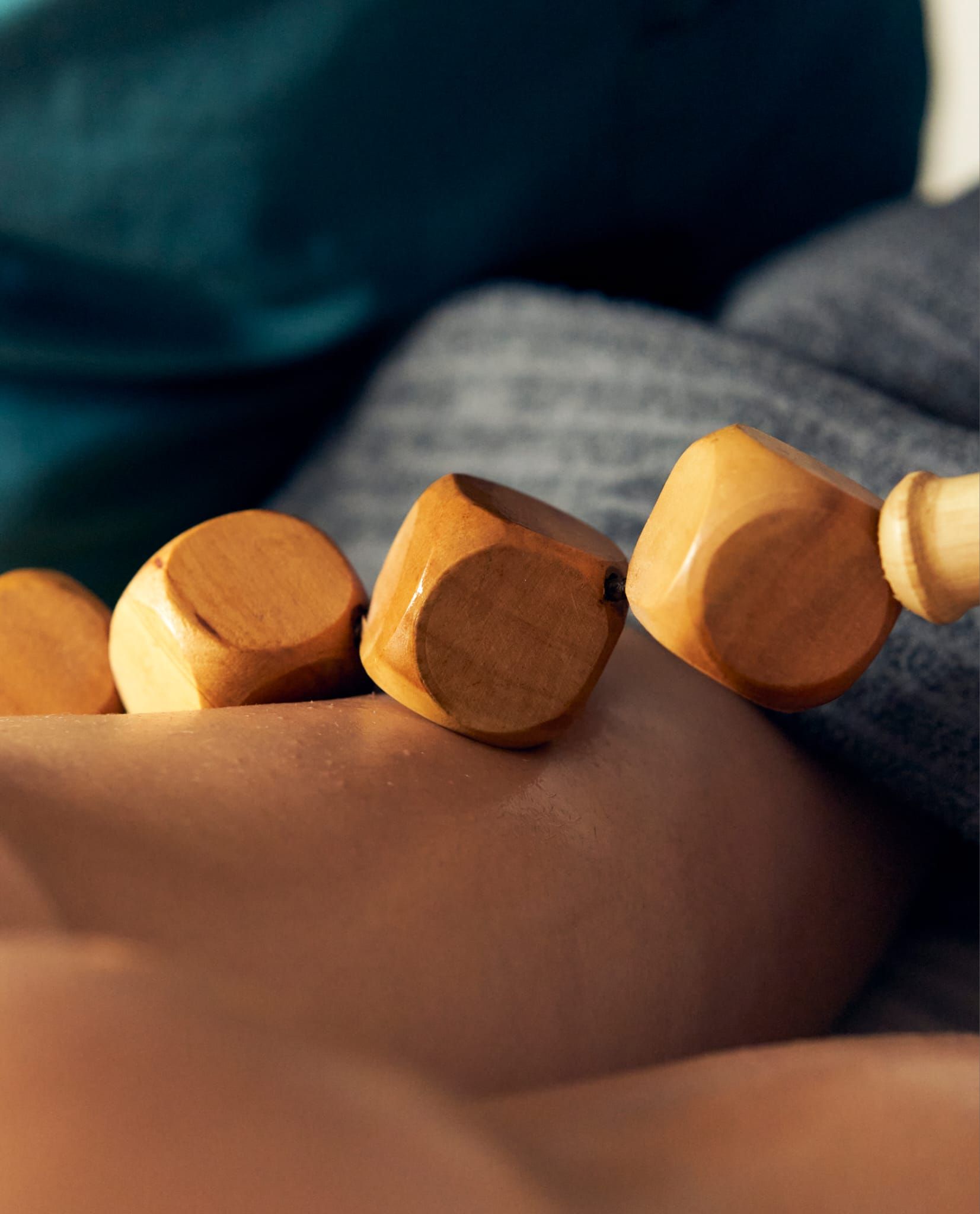 Herramienta de masaje de madera que rueda sobre la piel; enfoque suave.