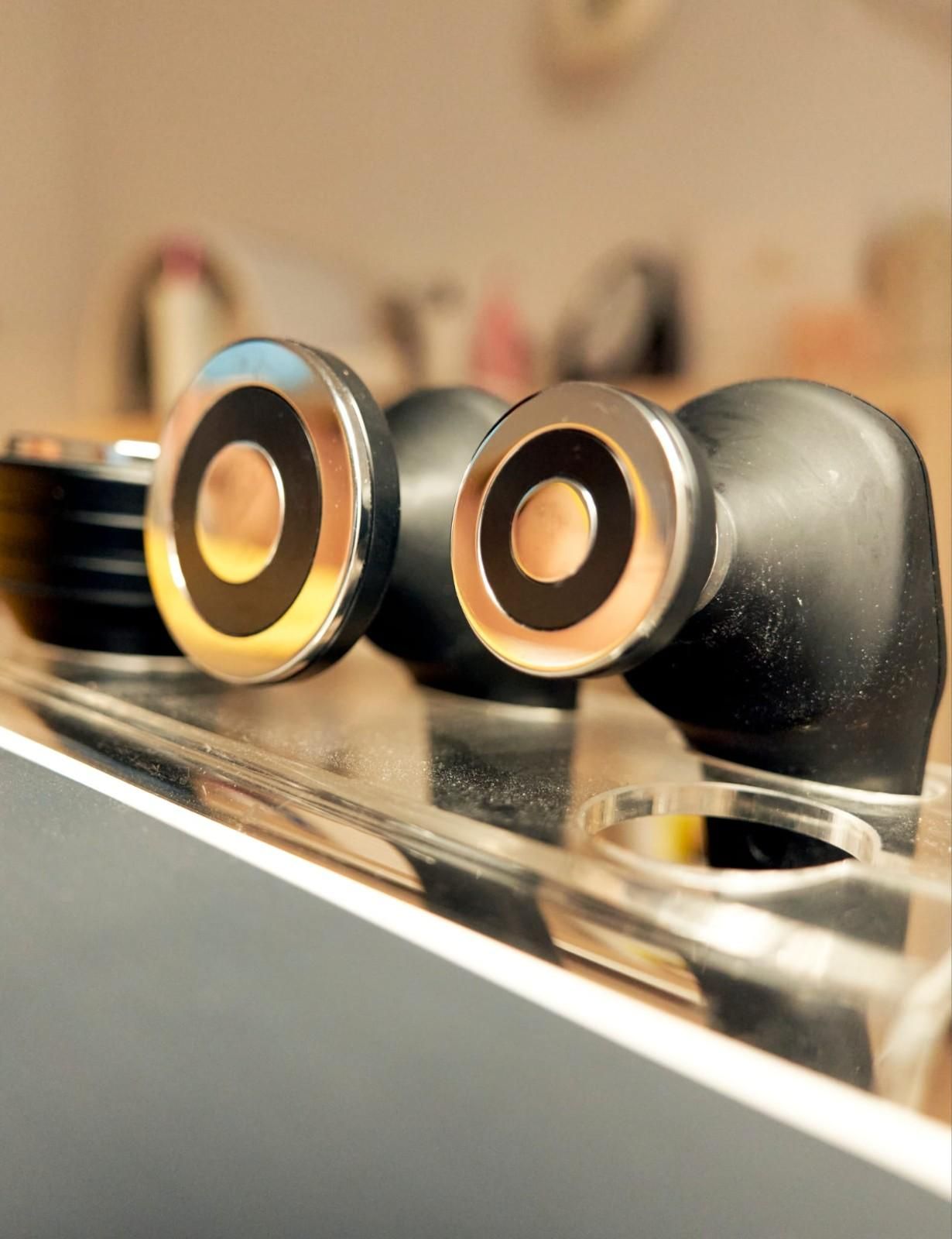 Tres botones negros y plateados sobre una superficie plateada, fondo borroso, toma de primer plano.