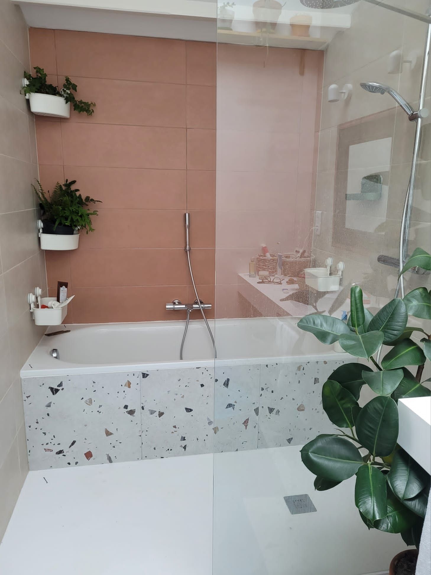 Salle de bain avec mur rose et décoration végétale