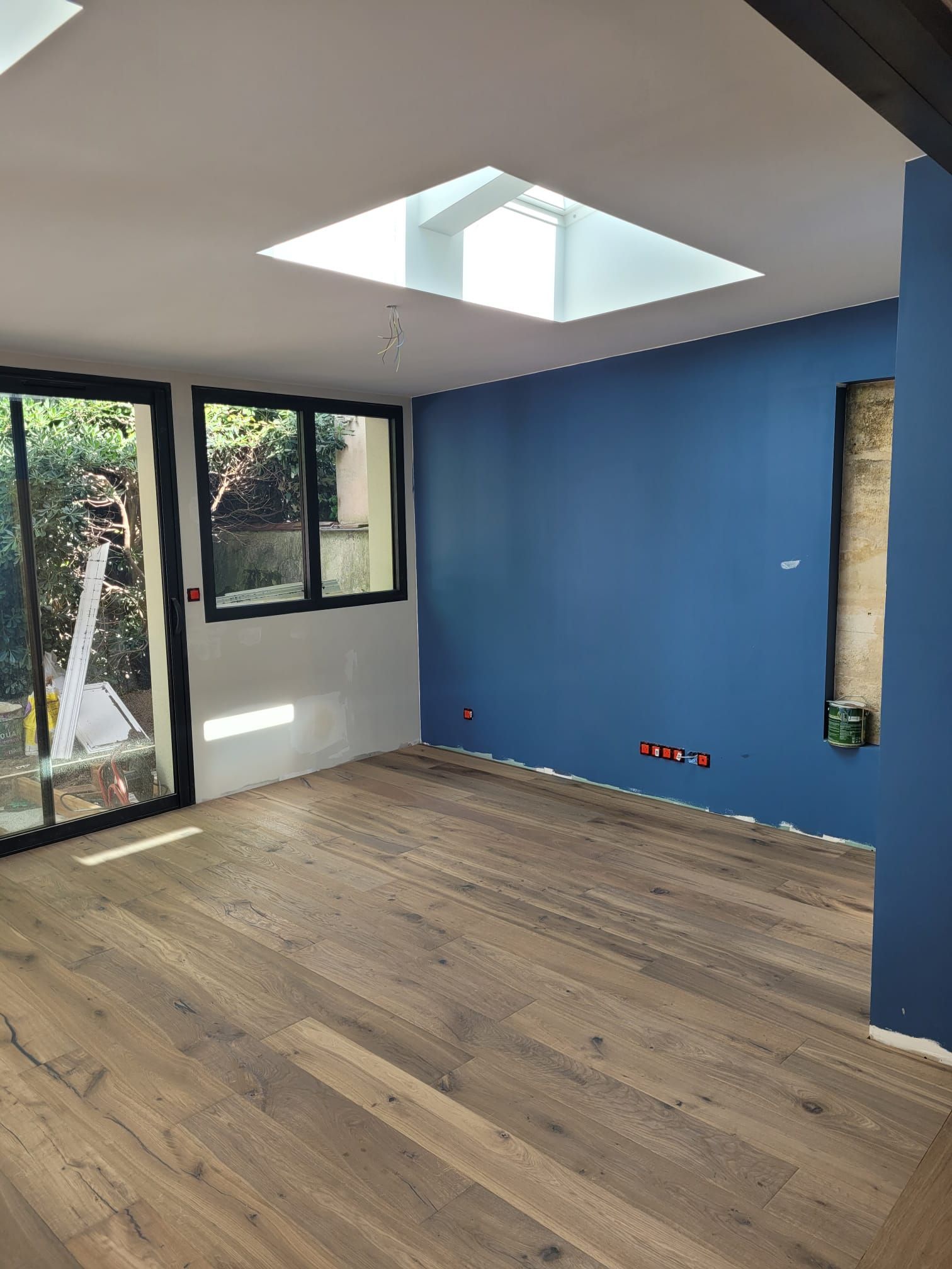 Salon spacieux avec baie vitrée et mur bleu