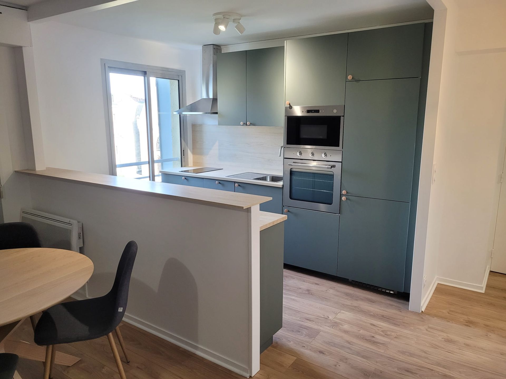 Cuisine ouverte avec îlot et mur bleu