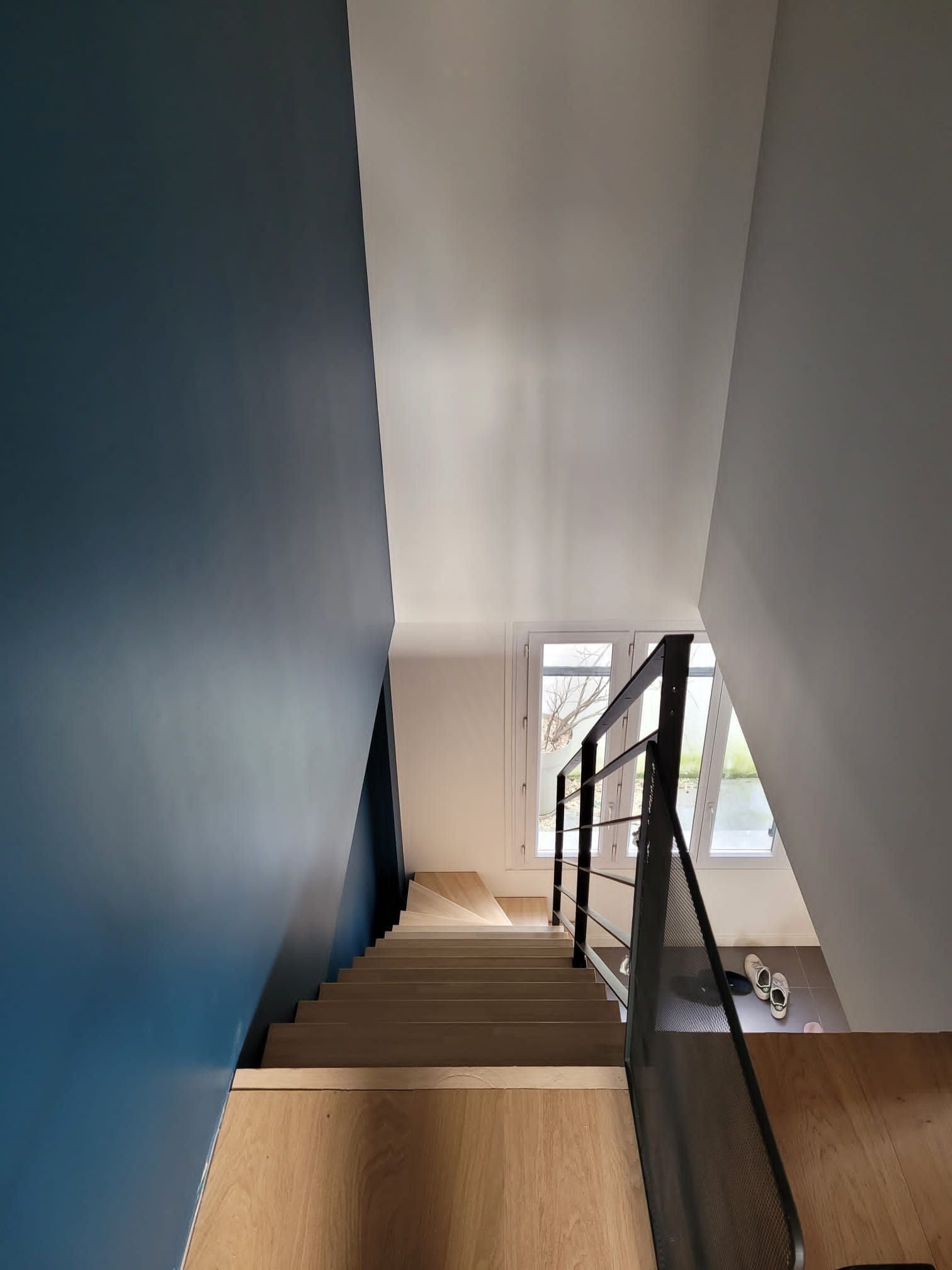 Escalier avec mur bleu et lumière naturelle