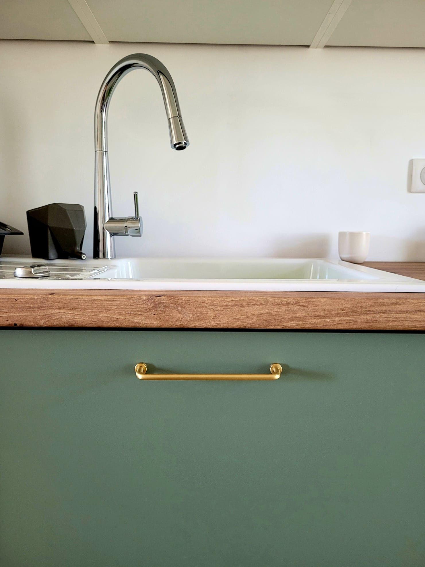 Cuisine moderne avec meubles verts et robinet doré