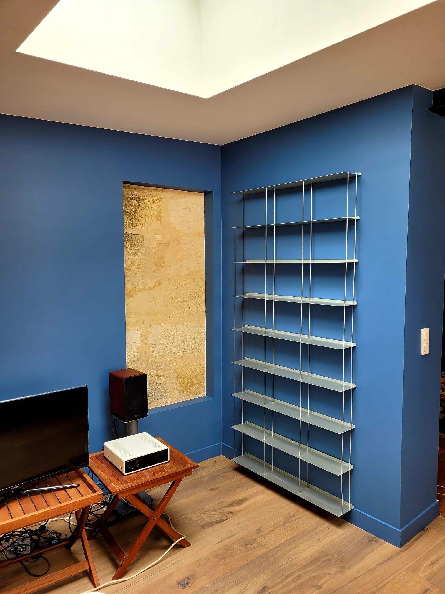 Coin bureau avec bibliothèque bleue et mur coloré