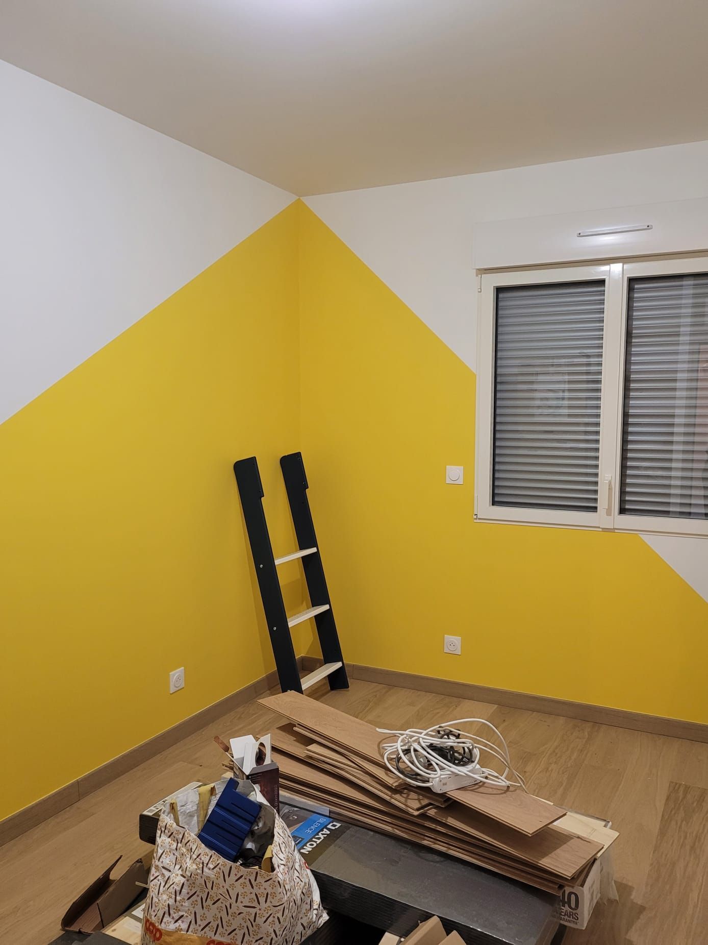 Pièce en rénovation avec mur jaune dynamique