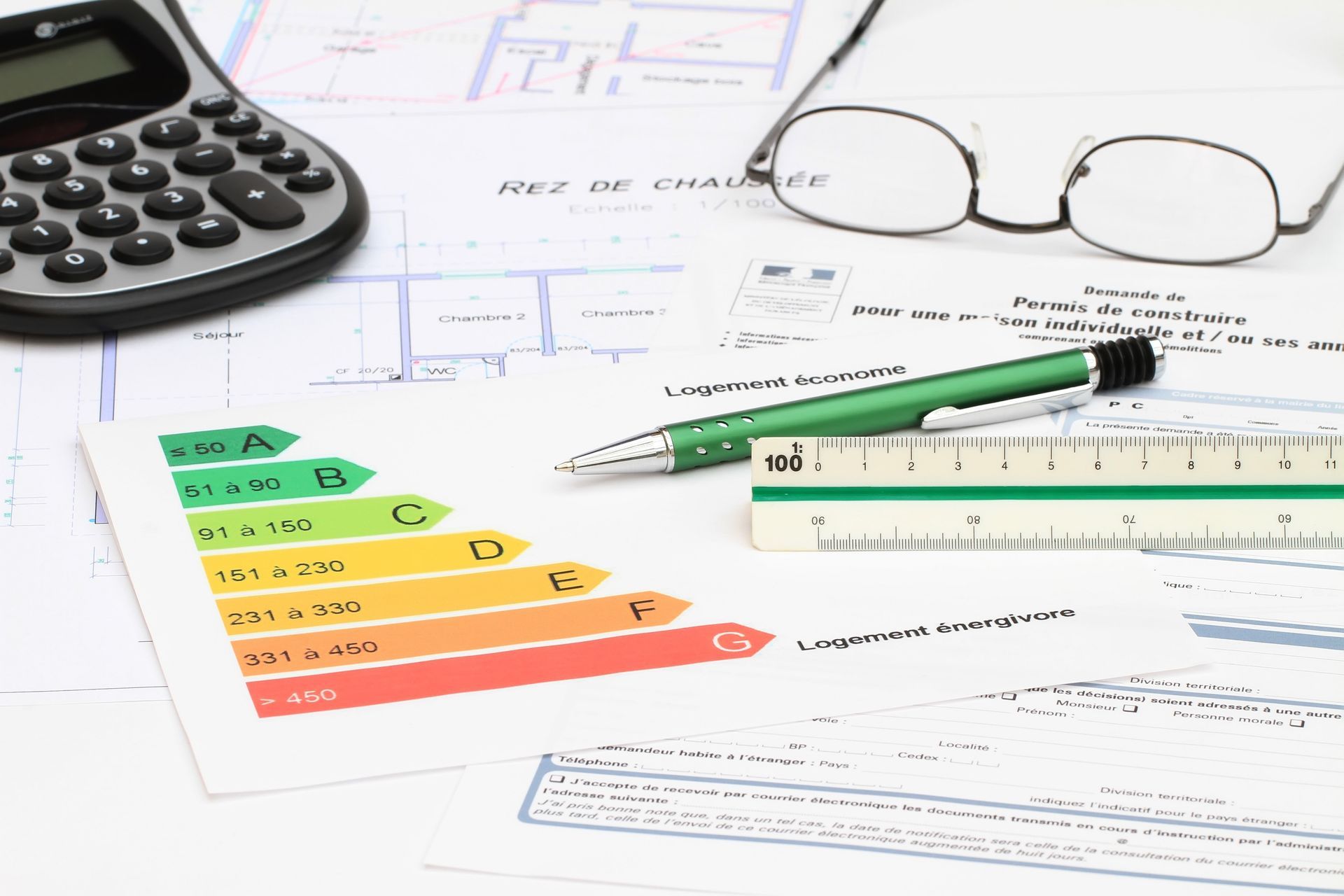 Documents sur l’efficacité énergétique avec une calculatrice, des lunettes, une règle, un stylo et un graphique de classement.
