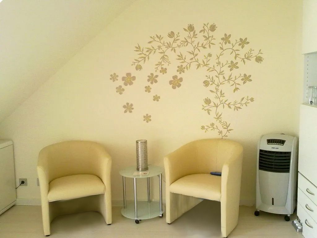 Zwei Stühle und ein Tisch in einem Raum mit einem Baum an der Wand