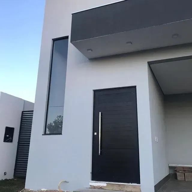 Una casa blanca con una puerta negra y una ventana grande