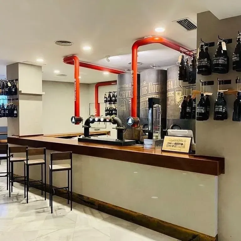 Un bar con botellas colgadas en la pared y un cartel que dice 