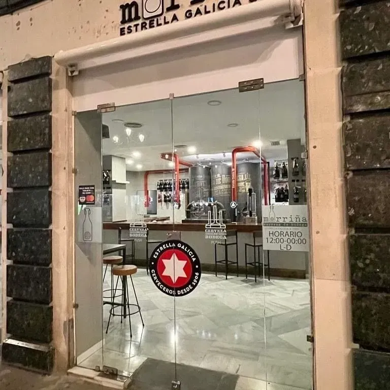 Un restaurante llamado Estrella Galicia tiene una puerta de cristal.