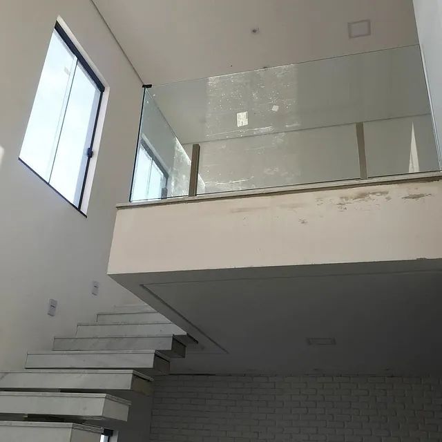 Una escalera con barandilla de vidrio que conduce al segundo piso.