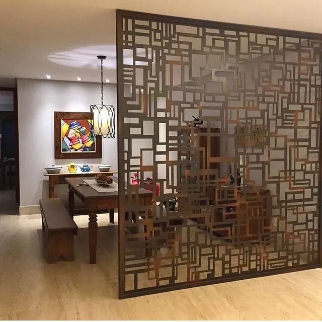 Una habitación con una mesa y sillas y un divisor.