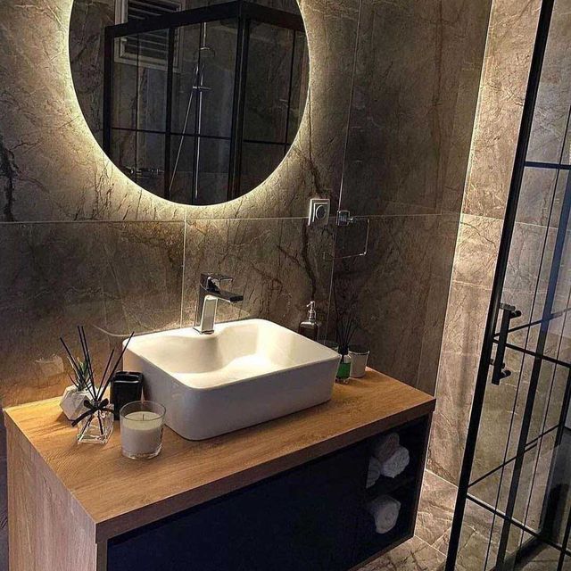 Un baño con lavabo, espejo y cabina de ducha.