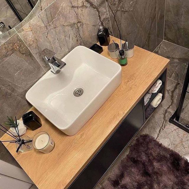 Un baño con un lavabo sobre una encimera de madera.